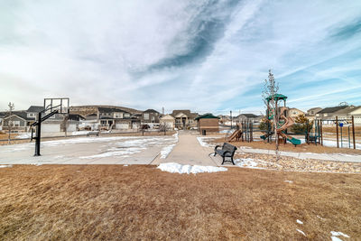 Houses on snow covered land against sky