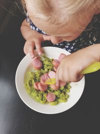 High angle view of girl holding ice cream on table