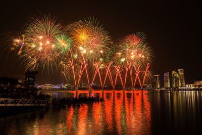 Firework display over river at night