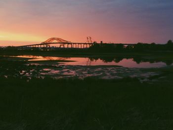 Bridge over river against sky during sunset