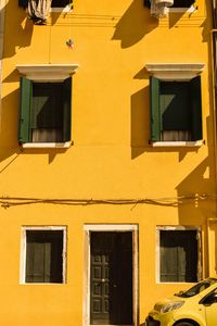 Low angle view of yellow building on sunny day