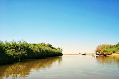 Scenic view of lake against clear blue sky