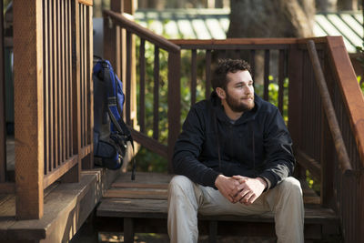 Man looking away while sitting on steps