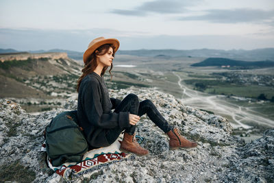 Portrait of young woman standing against mountain