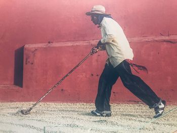 Side view of man working on wall