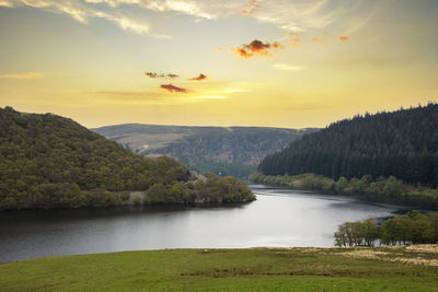 Scenic view of river against sky during sunset