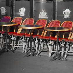 Empty chairs and tables in cafe against building