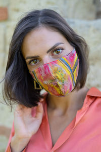 Portrait of woman covering face with multi colored hair