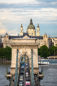 Bridge over river against buildings in city