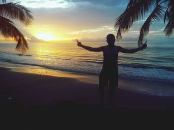 Silhouette of people on beach at sunset