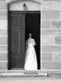 Rear view of bride standing on door