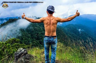 Full length of shirtless man against mountain