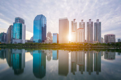 Reflection of buildings in river against sky