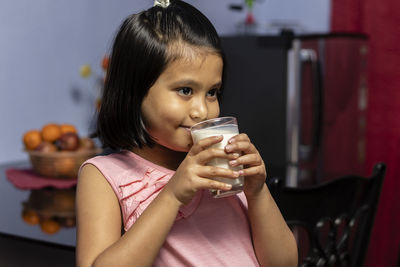 Portrait of mid adult woman holding drink at home