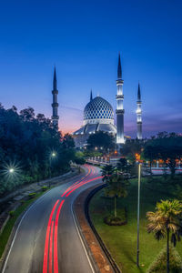 Light trails on road amidst buildings in city