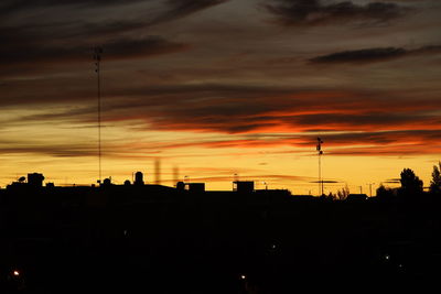 Silhouette buildings against sky during sunset