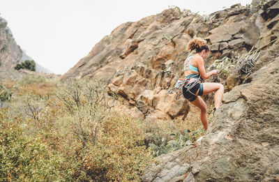 Woman climbing on rock