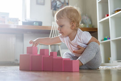 Cute girl playing with block shapes at home