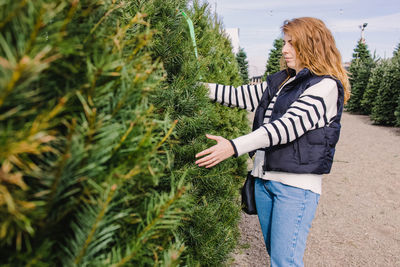Rear view of woman standing against plants