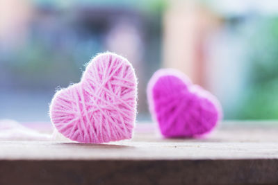 Close-up of heart shaped decoration made from wool on wooden table