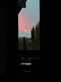 Silhouette trees seen through wet window during rainy season