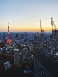 Modern buildings in city against sky during sunset