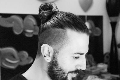 Close-up side view of young man with hairstyle looking down