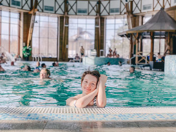 Portrait of young woman swimming in pool spa time 