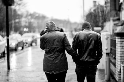 Rear view of people walking in rain