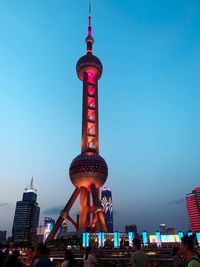 Communications tower in city against sky