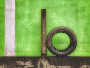 Tire against green wall