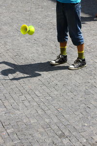 Low section of child playing with umbrella