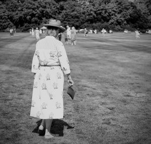 Rear view of women walking on field