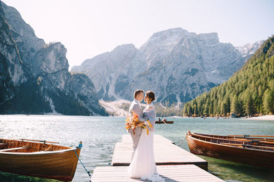 People on shore against mountains