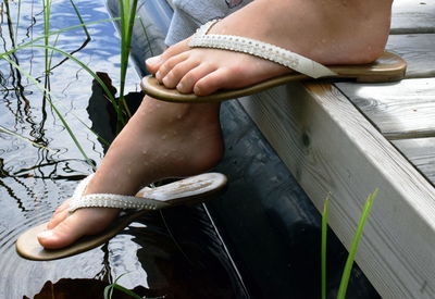 Low section of girl on pier over lake