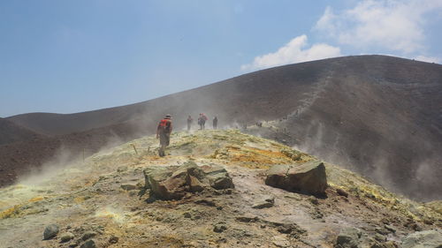 People hiking on mountain during foggy weather