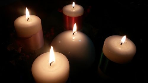 High angle view of illuminated candles against black background