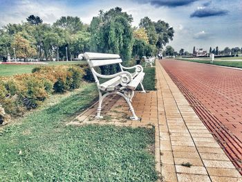 Empty seats in park against sky