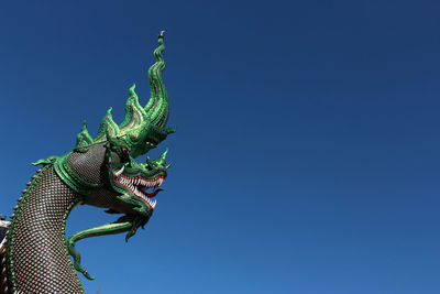 Low angle view of statue against blue sky
