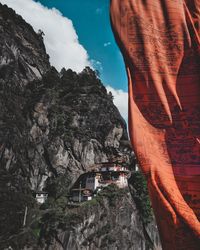 Low angle view of rock formation amidst buildings against sky