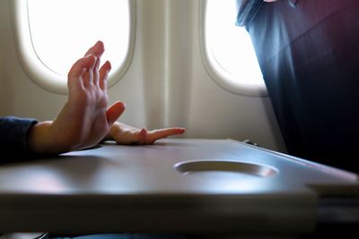 Cropped image of woman sitting in airplane