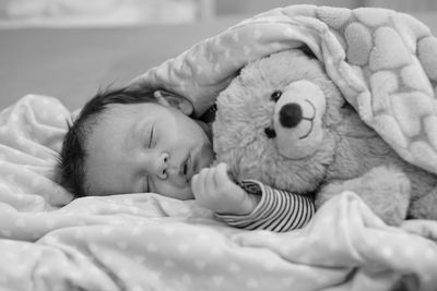 Cute baby boy sleeping with teddy bear