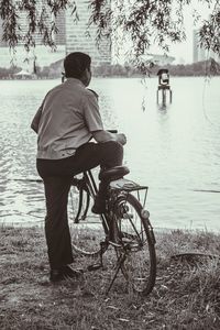 Rear view of woman standing on lakeshore