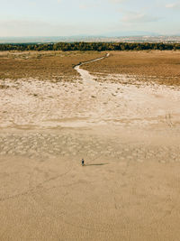 View of a person walking on sand