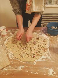 Midsection of woman preparing dumplings on table at home