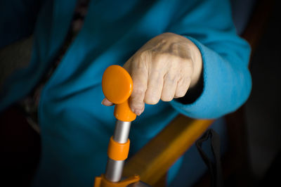 Midsection of senior woman holding walking cane