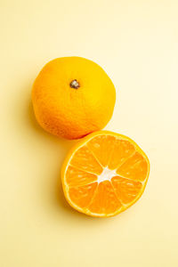 Close-up of orange fruit against pink background