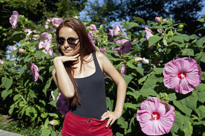 A young woman posing in front of a bush