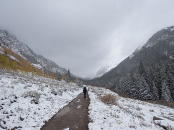 Man on snow covered mountain against sky