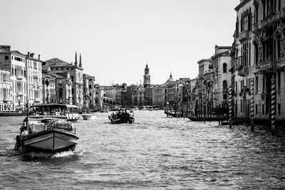 Boats in river with buildings in background